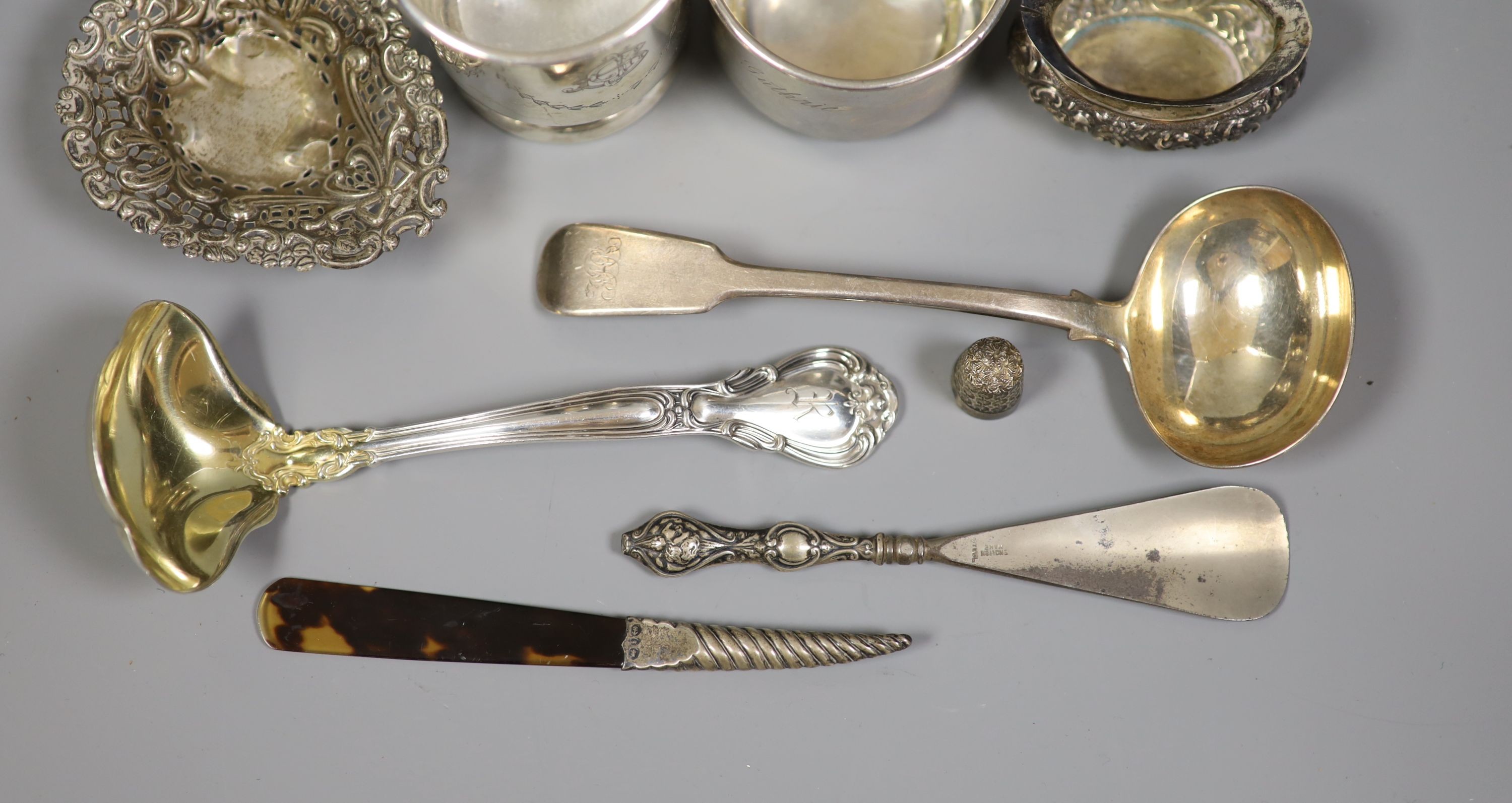 Mixed silver and sterling items including two mugs, two sauce ladles, salt thimble, nut dish and two silver handled implements